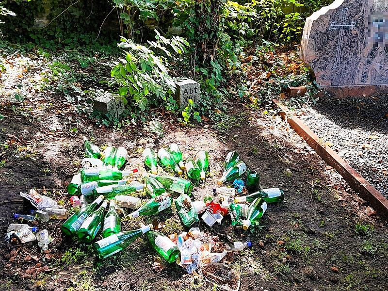 Leere Weinflaschen stapeln sich neben einem Grab auf dem Neuen Friedhof in Forchheim. Statt Frieden, Ruhe, Trauer gibt es immer wieder Ärger auf städtischen Friedhöfen - wegen illegalen Müllablagerungen.
