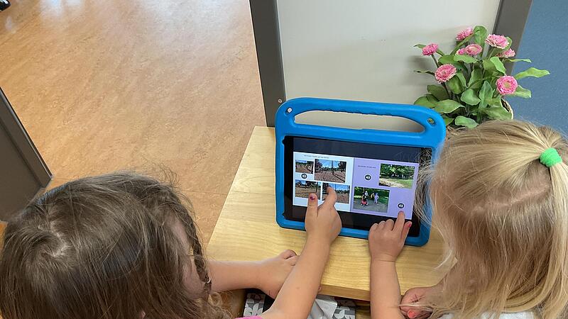 Kinder der Kita &bdquo;Im Grund&ldquo; in Buckenhofen betrachten auf dem Tablet ihr Bilderbuch.Forchheim & Fr&auml;nkische Schweiz