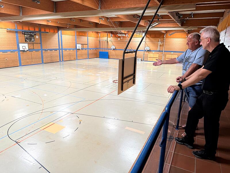 B&uuml;rgermeister Alexander Schulz (rechts) und Hans-Peter Philipp, Betriebsleiter des H&ouml;chstadter Sportzentrums, begutachten den an vielen Stellen &bdquo;geflickten" Estrich der Aischtalhalle.