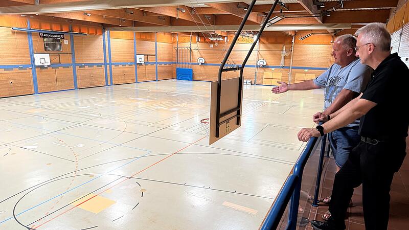 Aischtalhalle Bürgermeister Alexander Schulz (rechts) und Hans-Peter Philipp, Betriebsleiter des Höchstadter Sportzentrums, begutachten den an vielen Stellen „geflickten" Estrich der Aischtalhalle.