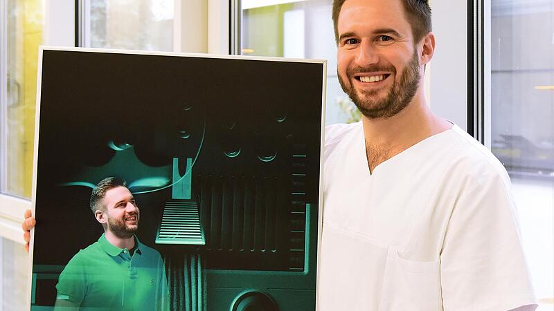 Florian Ammon pr&auml;sentiert sein Portr&auml;tbild, dass seine f&uuml;r die Kinder- und Jugendklinik Funktion als Gesundheits- und Kinderkrankenpfleger repr&auml;sentiert.