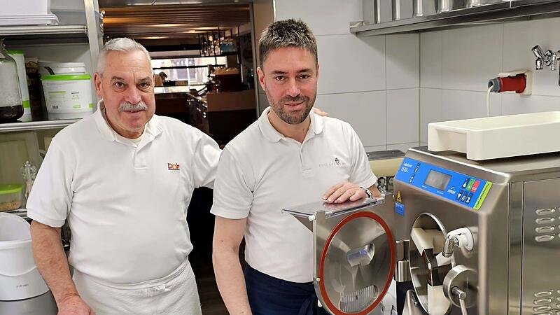 Silvano und Marco Stefani stehen an der Eismaschine im Produktionsraum ihres Eiscaf&eacute;s in Ebern. F&uuml;r die Preissteigerung ihrer Produkte haben sie gute Gr&uuml;nde.