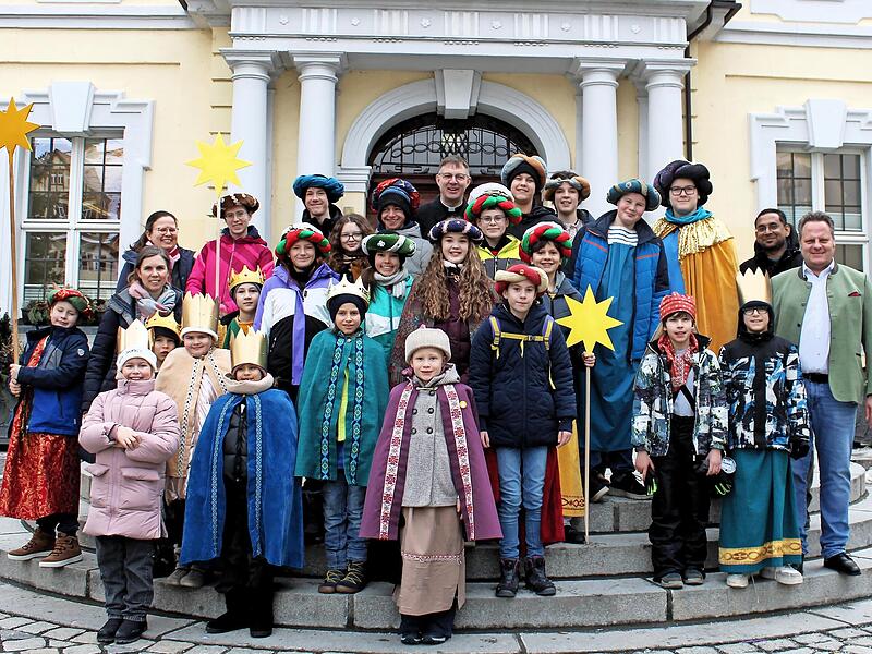 Traditionelles Gruppenfoto vor dem Kulmbacher Rathaus: Die Sternsinger besuchten mit Pfarrer Holger Fiedler (hinten Mitte), Kaplan Martin Varghese (Zweiter v.r.) und Pastoralreferentin Eva Maria Steltenkamp-H&uuml;sser (Zweite v.l.) den Kulmbacher Ober...