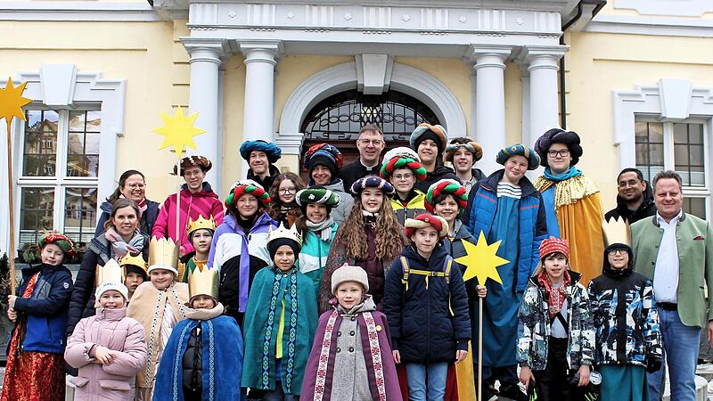 Traditionelles Gruppenfoto vor dem Kulmbacher Rathaus: Die Sternsinger besuchten mit Pfarrer Holger Fiedler (hinten Mitte), Kaplan Martin Varghese (Zweiter v.r.) und Pastoralreferentin Eva Maria Steltenkamp-H&uuml;sser (Zweite v.l.) den Kulmbacher Ober...