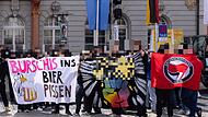 Protest gegen den Coburger Convent Auf diesem Archivfoto ist zu sehen, dass das umstrittene Banner bereits bei einer Anti-CC-Demo im Mai 2024 gezeigt wurde. Weil rechtlich nicht eindeutig geklärt ist, ob die Veröffentlichung des Motivs als Verbreitung einer möglichen Verunglimpfung staatlicher Symbole ausgelegt werden könnte, hat die Redaktion den Adler vorsorglich unkenntlich gemacht.