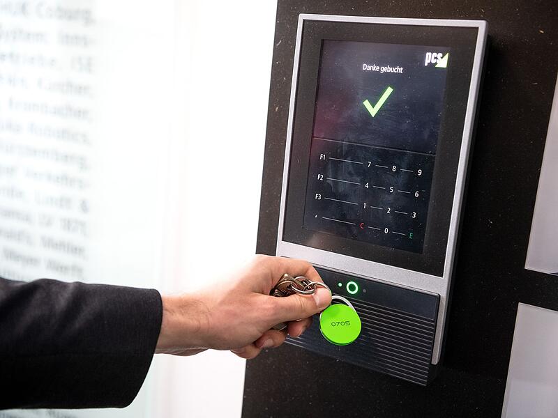 Ein Mitarbeiter erfasst seine Arbeitszeit an einem Terminal