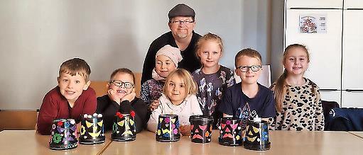Das Foto zeigt die Kinder mit ihrer selbst gebastelten Halloween- Deko aus leeren Joghurteimern zusammen mit Jungscharleiter Frank Preußners.