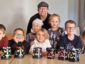 Das Foto zeigt die Kinder mit ihrer selbst gebastelten Halloween- Deko aus leeren Joghurteimern zusammen mit Jungscharleiter Frank Preußners.