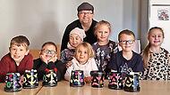 Das Foto zeigt die Kinder mit ihrer selbst gebastelten Halloween- Deko aus leeren Joghurteimern zusammen mit Jungscharleiter Frank Preußners.