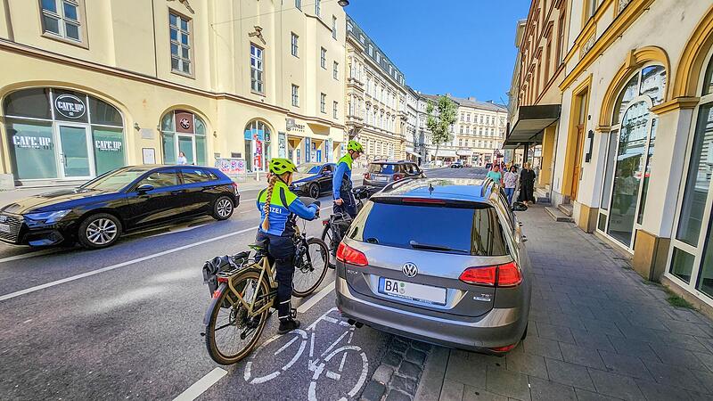 Mitten auf dem Radweg in der Luitpoldstra&szlig;e parkt dieser Autofahrer &ndash; eine Gefahrenstelle. Die Bamberger Polizisten fordern ihn auf, wegzufahren.