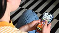 Eine Jugendliche sitzt auf dem Boden und nutzt ein Smartphone - auf dem Display sind verschiedene Apps zu sehen.  Altersgenossen von der Jungen Union fordern nun ein Social-Media-Verbot f&uuml;r Jugendliche.