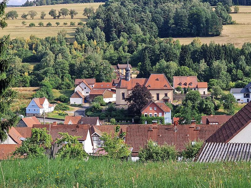 Wildflecken mit Blick auf Kirche und Pfarrhaus: Ein Ort, der immer wieder neue Menschen aufgenommen und integriert hat.