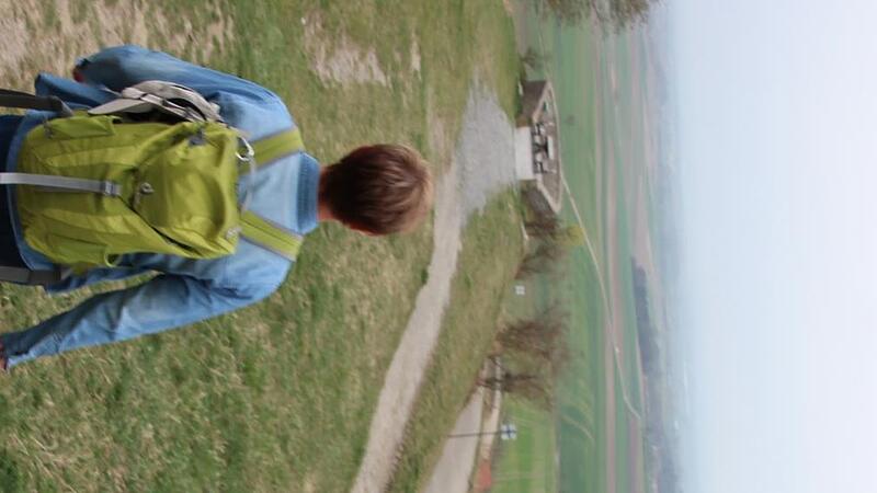 Auch, wenn das Wetter mal nicht ganz so sonnig ist, zieht Gabi L&ouml;sch gerne mit einem Rucksack und viel guter Laune los. Hier ist sie am Frankenblick bei Abtswind unterwegs.