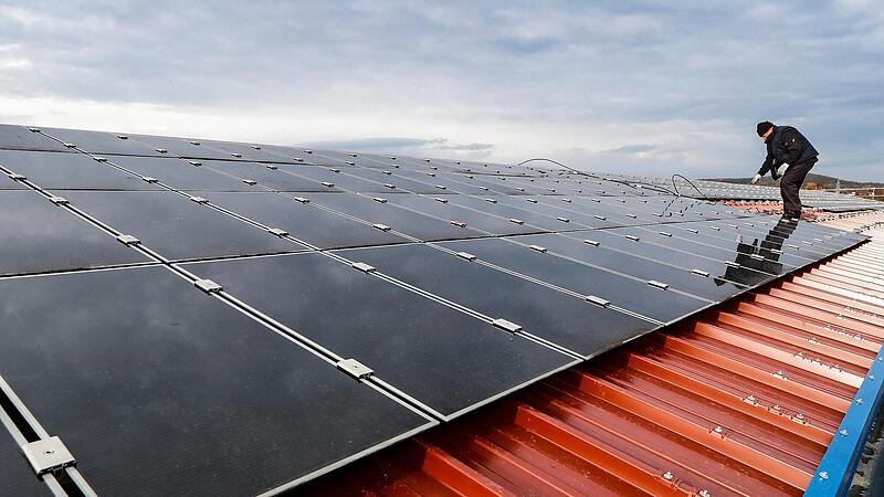 Ein Monteur installiert auf einem Dach Solarmodule. Die meisten dieser Module kommen aus China, die Produktion in Europa ist noch vergleichsweise gering.