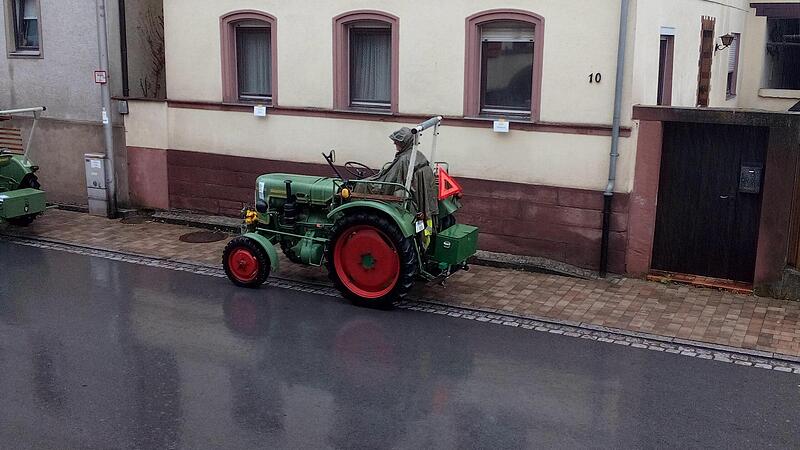 Im Regencape harrt dieser Fahrer auf seinem Traktor aus. Im Regencape harrt dieser Fahrer auf seinem Traktor aus.