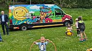 Kinder eröffnen am Spielplatz in Weihersbach die Saison des städtischen Spielmobils. Bürgermeister German Hacker (links) besucht sie.