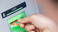 Ein Mann hebt am Automaten Geld ab
