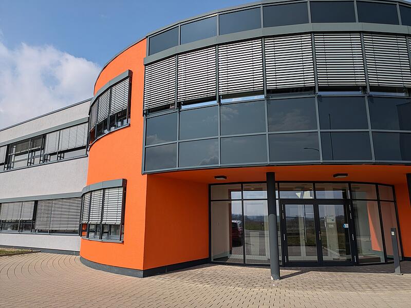 Die Geb&auml;ude von RWG by Kaman mit ihrem charakteristischen Orangeton begr&uuml;&szlig;en alle, die von Osten her &uuml;ber den Medbacher Weg nach H&ouml;chstadt hinein kommen.