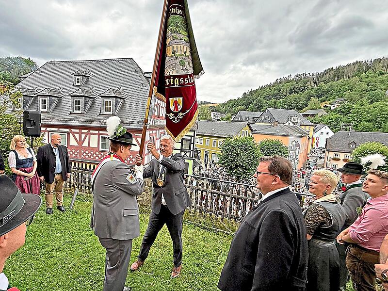 B&uuml;rgermeister Timo Ehrhardt &uuml;bergibt die Traditionsfahne.Florian Bauer