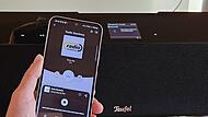 Ein Smartphone ist per Bluetooth an eine Stereoanlage gekoppelt.