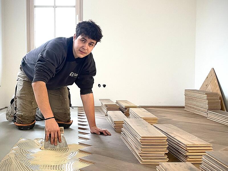 Mit Pr&auml;zision verteilt Nicolas den Parkettbodenkleber auf dem Untergrund.