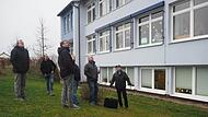 Die Mitglieder des Bau- und Umweltausschusses der Gemeinde Weidhausen haben sich bei einem gemeinsamen Rundgang mit Architekt und Ingenieur Bernd Schott (rechts) ein Bild vom Zustand der Außenfassade der Grundschule gemacht.