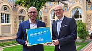 Staatsminister Fabian Mehring (links) mit Bad Kissingens Oberbürgermeister Dirk Vogel bei der Übergabe der Plakette "Digitales Amt" am 21. Oktober 2024