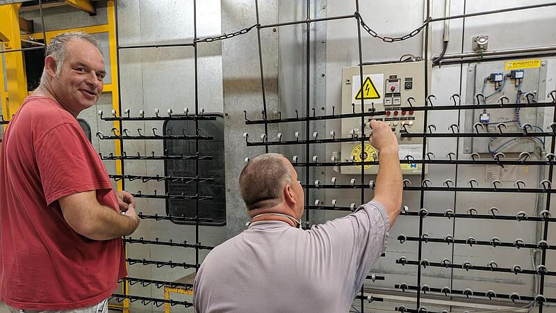 Jürgen Obermeier (links) und Matthias Engert stecken die Teile auf ein Gestell, auf dem die Metallstücke dann pulverbeschichtet und gebrannt werden. Jürgen Obermeier (links) und Matthias Engert stecken die Teile auf ein Gestell, auf dem die Metallstücke dann pulverbeschichtet und gebrannt werden.