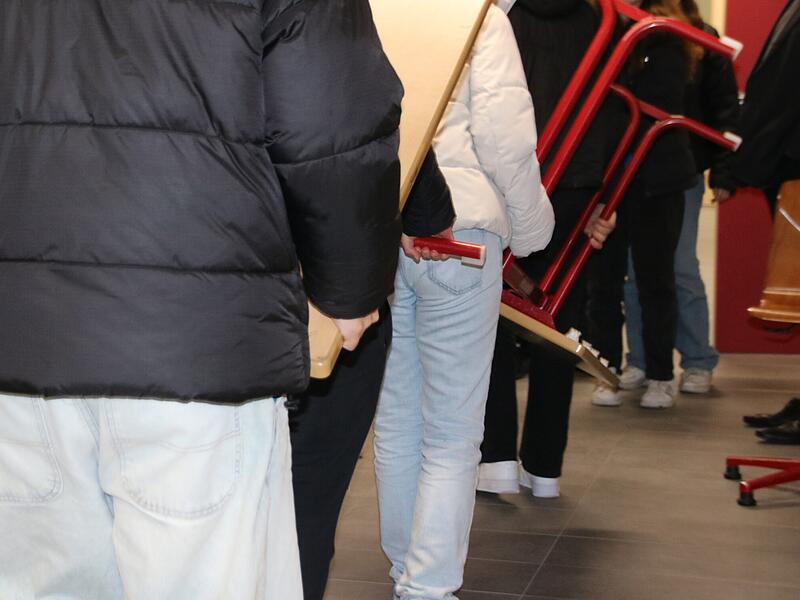 Sch&uuml;lerinnen und Sch&uuml;ler des Arnold-Gymnasiums tragen Tische in sanierte Klassenr&auml;ume