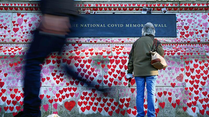Eine Frau liest Widmungen an der National Covid Memorial Wall in Westminster, einem Wandgem&auml;lde zum Gedenken an die Opfer der Pandemie. In England sollen in den n&auml;chsten Tagen fast alle verbleibenden Corona-Ma&szlig;nahmen enden.