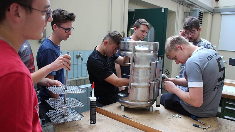 Duale Studenten bauen einen Drehgrill f&uuml;r die Tourismusschule.