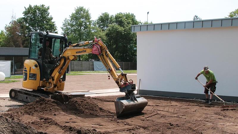 Mitarbeiter der Firma Gartenkult legen den Au&szlig;enbereich der neuen Sauna an.