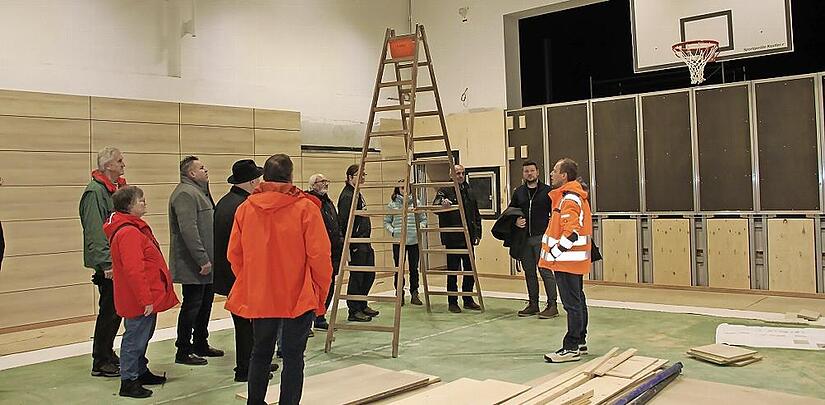 Bautechniker Frank S&ouml;llner informierte die Mitglieder des Bauausschusses bei einem Ortstermin &uuml;ber die Sanierungsarbeiten in der Grundschulturnhalle, die Mitte Januar 2026 abgeschlossen sein werden.