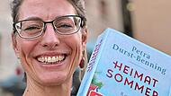 Die Mitarbeiterin der Stadtb&uuml;cherei H&ouml;chstadt Rebekka Ludwig empfiehlt &bdquo;Heimatsommer&ldquo;.