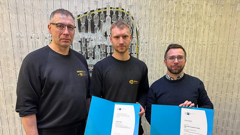 Ausbilder Andreas Perkowski (von links), Absolvent Lukas Fiedler und Ausbildungsmanager Dominik K&uuml;nzel halten die Urkunden f&uuml;r den Geehrten und Heinz-Glas in den H&auml;nden.