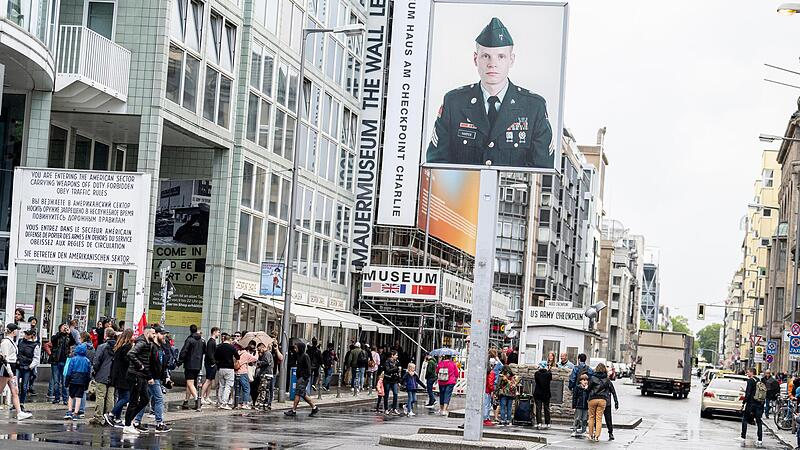 Touristen besuchen den ehemaligen Grenzübergang am Checkpoint Charlie. Touristen besuchen den ehemaligen Grenzübergang am Checkpoint Charlie.