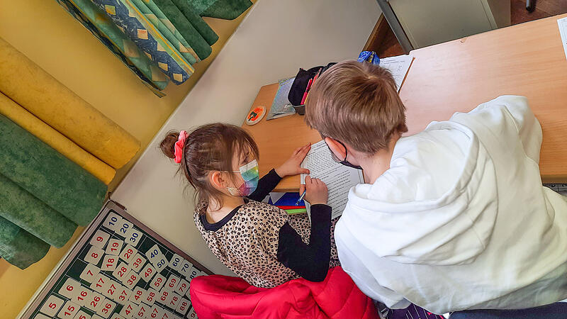 Evgenia (links) macht zusammen mit ihrem Nachhilfelehrer Artjom Hausaufgaben.
