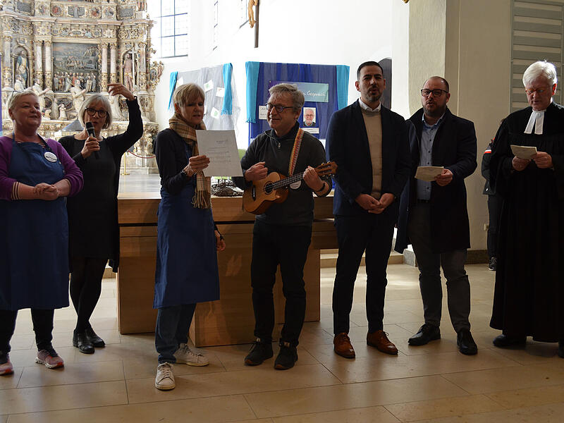 Vorm Essen wird das Mittagslied gesungen: Maria Kollo, Gabriele Töpfer, Christel Landner, Stefan Kornherr, Can Aydin, Sebastian Straubel und Heinrich Bedford-Strohm (v.l.).
