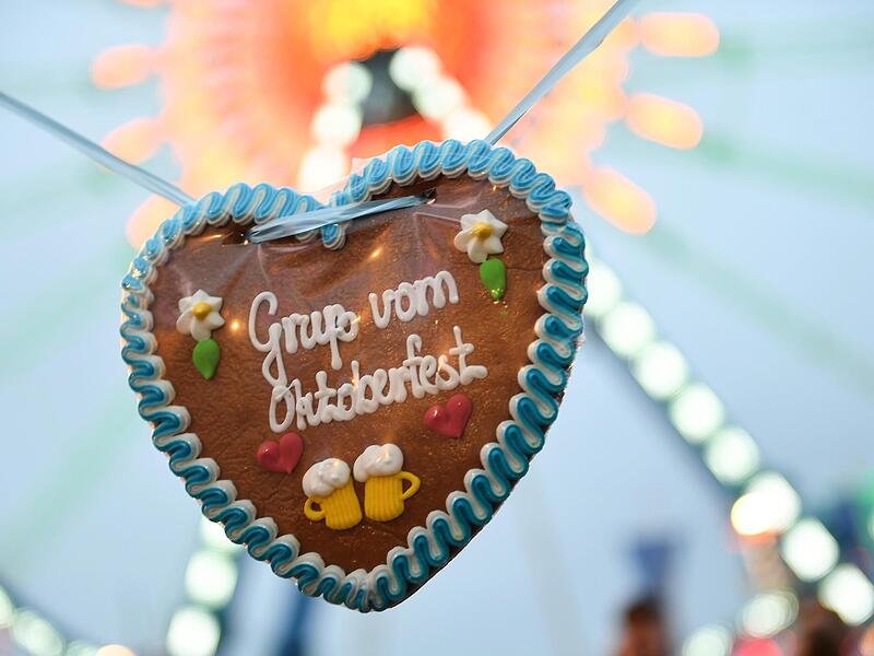Ein Wiesn-Herz mit der Aufschrift „Gruß vom Oktoberfest“ auf der Theresienwiese vor dem Riesenrad