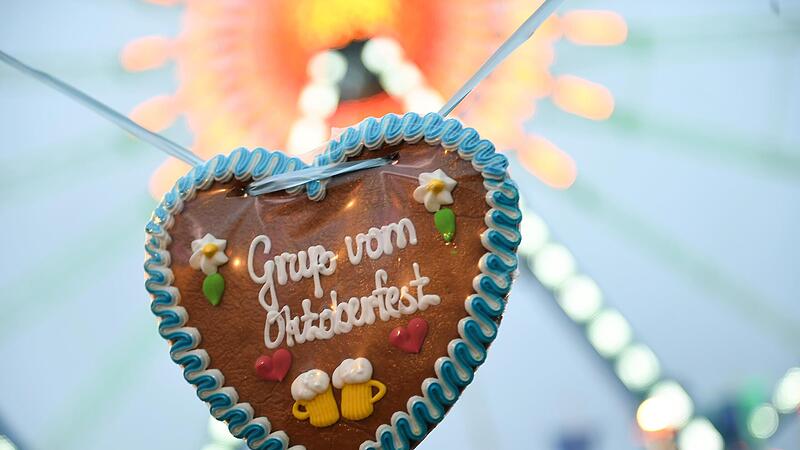 Ein Wiesn-Herz mit der Aufschrift „Gruß vom Oktoberfest“ auf der Theresienwiese vor dem Riesenrad