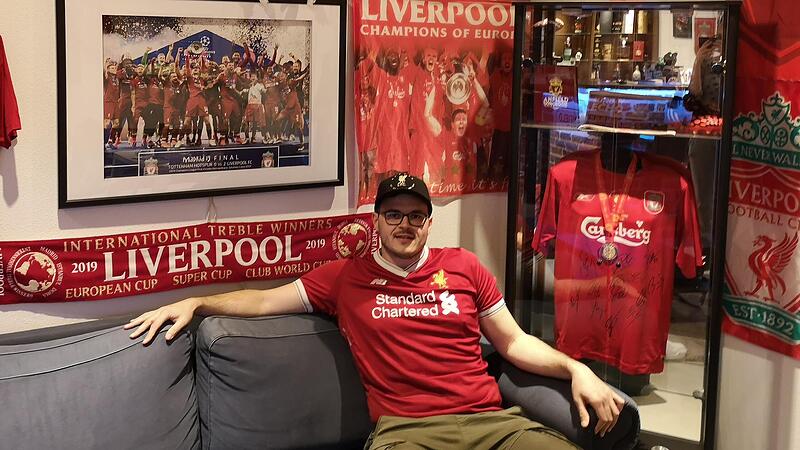 Sein Herz schlägt für die Reds: Sebastian Schnorr aus Hirschaid in seiner Bar, die voll mit Fanartikeln des FC Liverpool ist. In der Vitrine hinten rechts ist ein unterschriebenes Trikot der Champions-League-Sieger-Mannschaft von 2005 und ein unterschriebener Schuh von Gerrard. Dass der LFC an der Super League teilgenommen hätte, enttäuscht den 32-Jährigen.