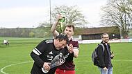 Adrian Brehm verpasst seinem Trainer Mario Lochmann nach der Kreisliga-Meisterschaft eine Sektdusche.