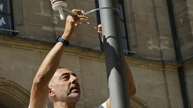Louay Yassin montiert einen Sensor an einem Leuchtenmast. Louay Yassin montiert einen Sensor an einem Leuchtenmast.
