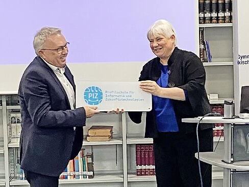 Martina Schmidt-Kessel, die Stellvertreterin des Ministerialbeauftragten für Oberfranken, bei der Übergabe des PIZ-Schildes an Schulleiter Siegfried Reck.