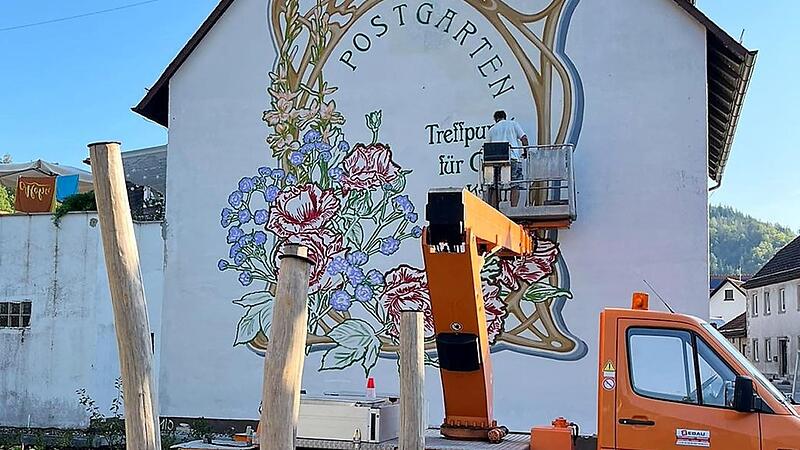 Sprayer Alex zaubert herrlich leuchtende Farben mit seinen Spraydosen an die kahle Hauswand im Postgarten in Steinwiesen.