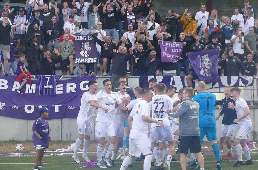 Die Spieler des FC Eintracht Bamberg jubeln nach dem Derbysieg bei der DJK Bamberg zusammen mit ihren Fans.