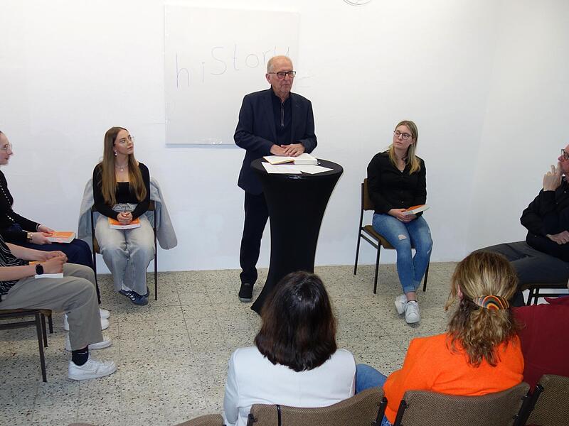 Otmar Adlers (stehend) Autobiografie wurde bei der ersten Veranstaltung im „Maxhaus“ 2026 von jungen Stimmen auszugsweise vorgestellt. Nils Graf, Sophia Müller, Andrea Fröhlich und Annika Neidhardt lasen, Rudolf Ruf (von links) moderierte den Abend. Otmar Adlers (stehend) Autobiografie wurde bei der ersten Veranstaltung im „Maxhaus“ 2026 von jungen Stimmen auszugsweise vorgestellt. Nils Graf, Sophia Müller, Andrea Fröhlich und Annika Neidhardt lasen, Rudolf Ruf (von links) moderierte den Abend.