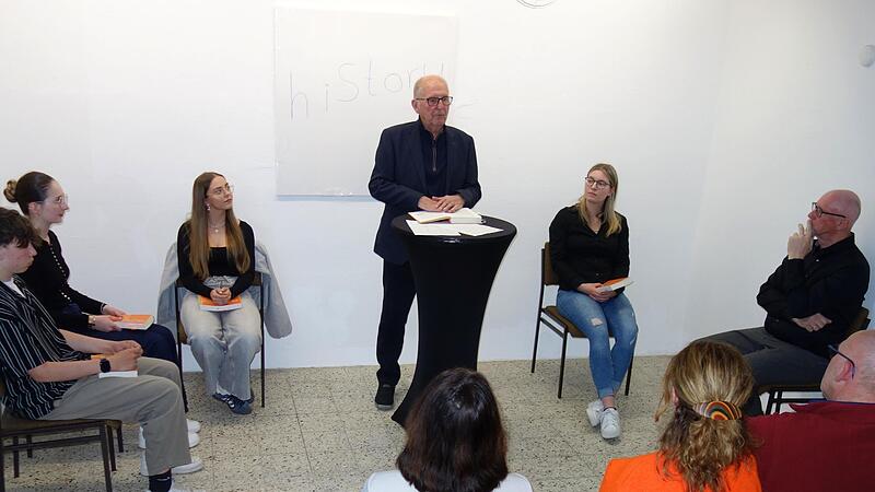 Otmar Adlers (stehend) Autobiografie wurde bei der ersten Veranstaltung im &bdquo;Maxhaus&ldquo; 2026 von jungen Stimmen auszugsweise vorgestellt. Nils Graf, Sophia M&uuml;ller, Andrea Fr&ouml;hlich und Annika Neidhardt lasen, Rudolf Ruf (von links) moderierte den Abend.