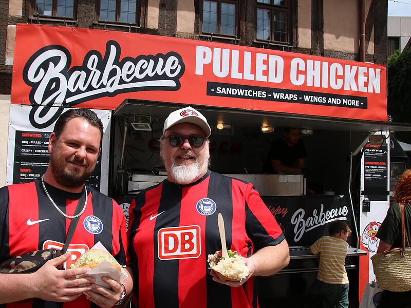 Patrick (links) und Stefan aus Berlin genießen Pulled Burger beim Streetfoodfestival 2024 in Bad Kissingen