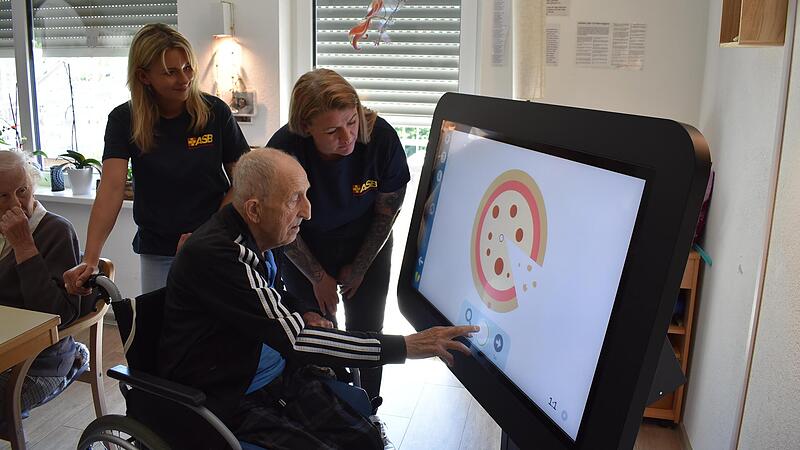 An dem großen Tablet tippt einer der Tagesgäste mit dem Finger auf einen Kreis und zieht ihn hoch in die passende Lücke. Es ist fast wie ein Puzzle, nur mit unterschiedlichen Formen.Forchheim & Fränkische Schweiz